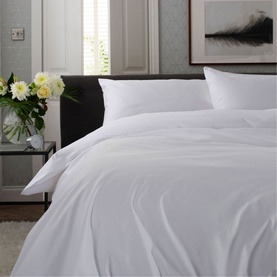 The Lyndon Company 1000 Thread Count Pillowcase in white, styled on a made bed with matching white duvet cover and fresh flowers