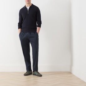 Model wearing Samsoe & Samsoe Guna Half-Zip Sweater in navy, styled with matching navy trousers and khaki trainers