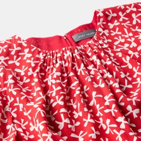 Mint Velvet Bow Print Ruffle Mini Dress in red and white bow print, showing ruffle neckline detail and gathered fabric