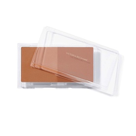 Victoria Beckham Beauty Matte Bronzing Brick bronzer in open clear compact, showing warm tan pressed powder pan