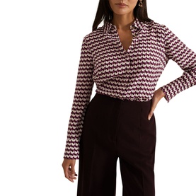 Model wearing Phase Eight Gina Printed Shirt in multi geometric print with long sleeves and classic collar, styled with dark wide-leg trousers