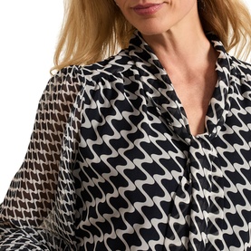 Model wearing Phase Eight Suki Printed Pussybow Mini Dress in blue geometric print, showing V-neckline, pussybow tie and semi-sheer sleeves
