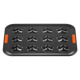 Le Creuset 12-Cup Non-Stick Bakeware Star Tray 40cm in grey with orange handles, featuring 12 star-shaped cups