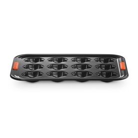 Le Creuset 12-Cup Non-Stick Star Tray 40cm in black with orange silicone handles, featuring 12 star-shaped baking cups