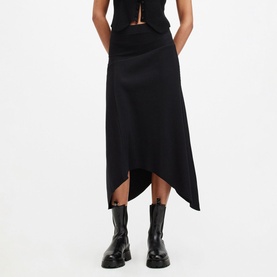 Model wearing All Saints Gia Asymmetric Flared Skirt in black with elasticated waist and draped hemline, styled with black crop top and chunky boots