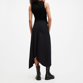 Model wearing All Saints Gia Asymmetric Flared Skirt in black with elasticated waist and asymmetric hem, styled with black tank and chunky boots