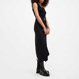 Model wearing All Saints Gia Asymmetric Flared Skirt in black with flared silhouette and asymmetric hem, styled with black boots