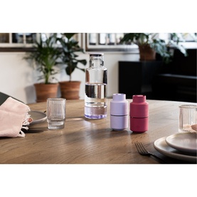 CrushGrind Billung Grinder in lilac on a dining table, styled with a pink grinder, glass carafe, tumbler, and plates