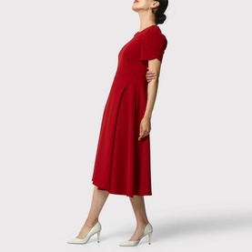 Model wearing Helen McAlinden Vera Fit-And-Flare Dress in red, midi length with round neckline and short puffed sleeves, styled with white heels