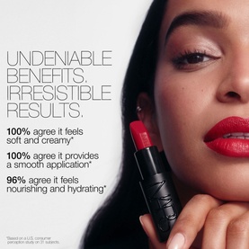 Model wearing NARS Explicit Lipstick in Incendiary, a bold red shade, shown alongside promotional benefit claims text