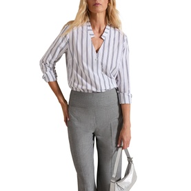 Model wearing Phase Eight Ashlyn Asymmetric Striped Blouse in white with grey stripes, V-neckline, wrap front, styled with grey trousers