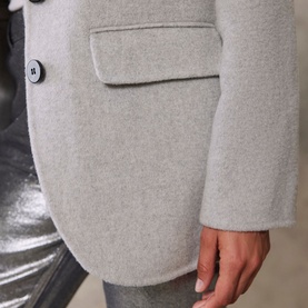 Model wearing Mint Velvet Grey Single-Breasted Blazer, close-up of flap pocket and button detail, styled with silver metallic trousers