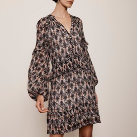 Model wearing Mint Velvet Ruffle-Detail Printed Dress in beige, floral print, V-neck, puffed sleeves, tiered mini skirt with ruffle hem