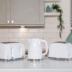 Russell Hobbs Honeycomb 4 Slice White Toaster styled with matching white kettle and 2-slice toaster on kitchen worktop
