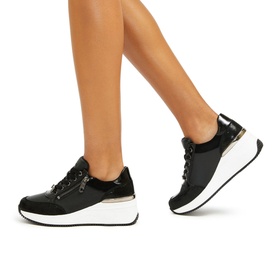 Model wearing Carvela Skyline Platform Trainers in black leather with lace-up fastening, zip detail, gold-tone accents and white platform sole