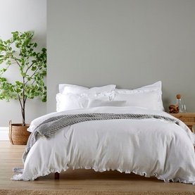 Christys Organic Retreat Ruffle Duvet Set in white on a made bed, featuring delicate ruffle edging and relaxed cotton finish
