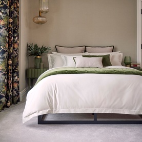Christys 500 Thread Count Hygro Duvet Set in Parchment, white sateen finish with green embroidered border, styled on a made bed