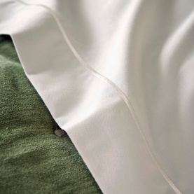 Christys 500 Thread Count Hygro Duvet Set in Parchment, grey sateen finish cotton, shown draped over green fabric bedding