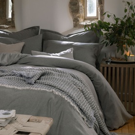 Christys Flannel Marl Duvet Set in silver, 100% brushed cotton with soft finish, styled on a bed with coordinating pillowcases