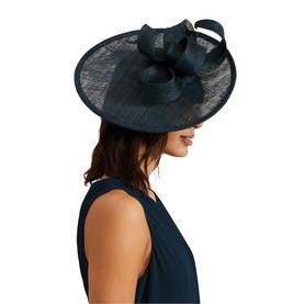 Model with Phase Eight Bow-Detail Fascinator in navy blue, wide-brim sinamay with bow, worn with matching sleeveless dress