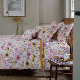 The Lyndon Company Mary Mary Duvet Set in multi floral pink and yellow print, styled on a wooden bed with matching pillowcases