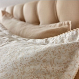 Christys Daisy Meadow Duvet Set Hazelnut in brown, 100% cotton sateen with floral print and piped trim, styled on a bed