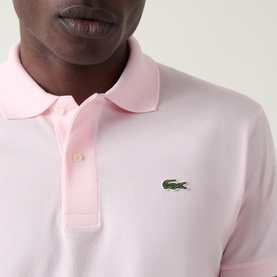 Model wearing Lacoste Heritage Logo Piqu&eacute; Polo Shirt in light pink with polo collar, two-button placket, and embroidered crocodile logo