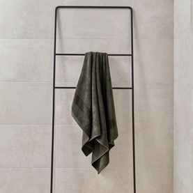 Christys Prism Towel in Tarmac black draped over a black ladder rail, soft 100% Turkish cotton with subtle tonal stripe detail