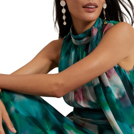 Model wearing Phase Eight Lucinda Floral Dress in teal multi watercolour print, sleeveless with high neckline, styled with drop earrings