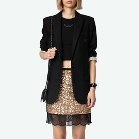 Model wearing Zadig Sequin Mini Skirt in gold with lace hem trim, styled with black blazer and mini crossbody bag