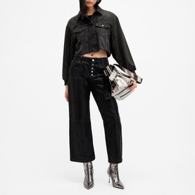 Model wearing All Saints Anders Embellished Cropped Denim Jacket in black with wide-leg black jeans and silver snake-print ankle boots