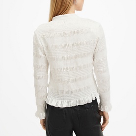 Model wearing All Saints Meg Textured Shirt in white, showing back view with frill hemline and long sleeves, styled with black jeans