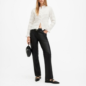 Model wearing All Saints Meg Textured Shirt in white with collarless neckline and frill hem, styled with black trousers and mule heels
