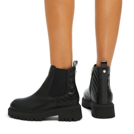 Model wearing Carvela Ace Chelsea Boots in black with chevron quilting, Icon C pull tab, side zip, and chunky tread sole