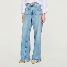 Model wearing Sandro Patch Pocket Wide Leg Jeans in blue jean, styled with a white top and espadrille flats. Wide-leg silhouette with patch pockets.