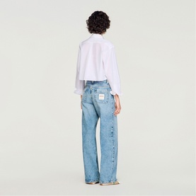 Model wearing Sandro Patch Pocket Wide Leg Jeans in blue jean, wide-leg fit, paired with a white shirt, rear view.