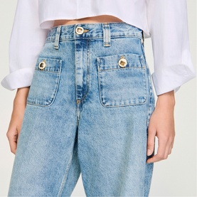 Model wearing Sandro Patch Pocket Wide Leg Jeans in blue jean, 100% cotton, featuring large front patch pockets with gold button detail.