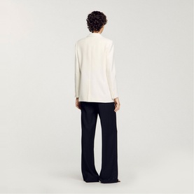 Model wearing Sandro Sequin Suit Blazer in clear, long sleeves, single-breasted, styled with wide-leg navy trousers, back view.