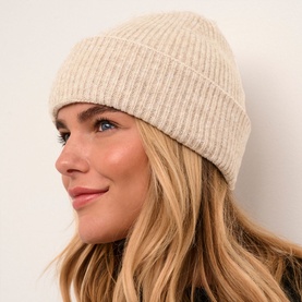Model with Kaffe Marlene Rib Knit Beanie in beige, featuring a turned-up brim and ribbed texture