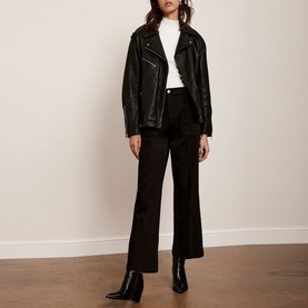 Model wearing Mint Velvet Black Cropped Wide Leg Jeans with a white top, black leather jacket, and black ankle boots
