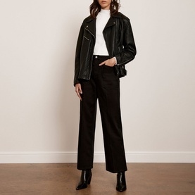 Model wearing Mint Velvet Black Cropped Wide Leg Jeans with a white roll-neck, black leather jacket and black ankle boots