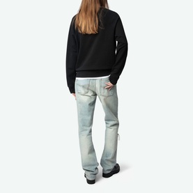 Model wearing Zadig Supper Printed Pullover Sweatshirt in black, shown from behind, styled with light-wash straight-leg jeans