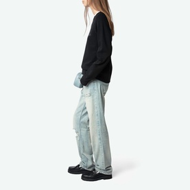 Model wearing Zadig Supper Printed Pullover Sweatshirt in black with light-wash distressed jeans and black chunky loafers