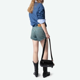 Model wearing Zadig Upper Devil Queen blue cotton sweatshirt, styled with denim shorts and black boots, carrying small black cylindrical bag