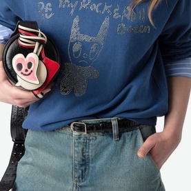 Model wearing Zadig Upper Devil Queen blue cotton sweatshirt with rhinestone detailing, styled with light-wash jeans and carried round novelty bag