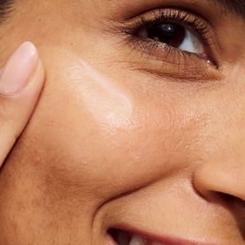 Model with CLINIQUE Even Better Clinical Dark Spot Clearing Serum applied to cheek, showing smooth, even-toned skin texture