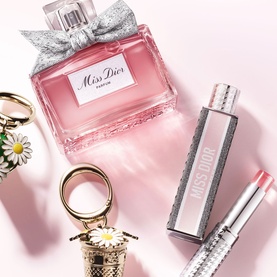 Dior Miss Dior Parfum and Mini Miss Solid Perfume in pink and silver packaging, styled with daisy keyring accessories