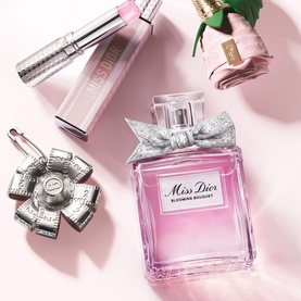 Dior Miss Dior Blooming Bouquet EDT in pink bottle with silver bow, styled with solid perfume compact and pink lipstick