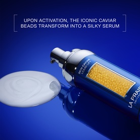 LA PRAIRIE Skin Caviar Liquid Lift 50ml serum with caviar beads visible, dispensing a silky white serum on a blue background