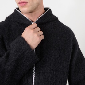 Model wearing Our Legacy Black Zip Through hoodie, featuring contrast stripe zip detail and fluffy wool-blend texture.